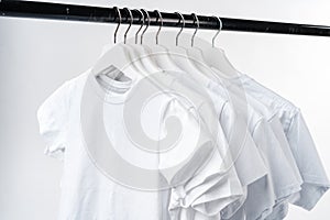 Clothes hang on clothing rack over white background.