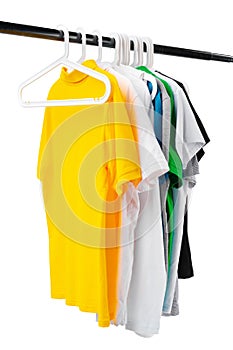 Clothes hang on clothing rack over white background.