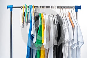 Clothes hang on clothing rack over white background.