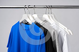 Clothes hang on clothing rack over white background.