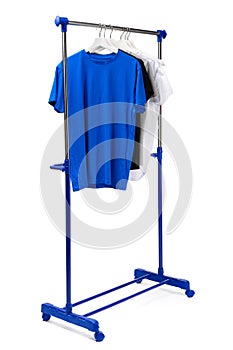 Clothes hang on clothing rack over white background.