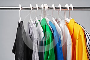 Clothes hang on clothing rack over white background.