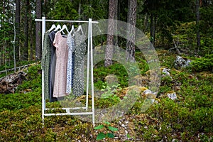 Clothes hanger with dresses in the woods.