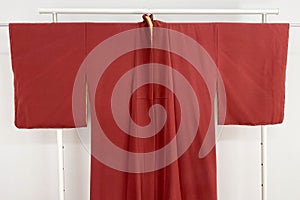 clothes hanger with red fabric on a white wall background.