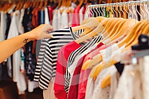 Clothes hangers with colorful clothes in a women shop. Summer sale.