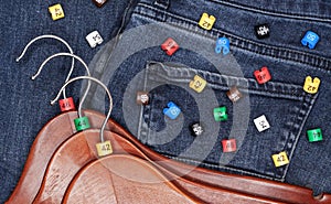 Clothes hangers with multicolored plastic size labels on a denim backdrop