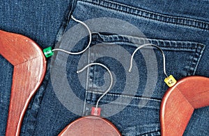 Clothes hangers with multicolored plastic size labels on a denim backdrop