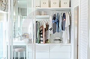 Clothes hanging in closet with hat