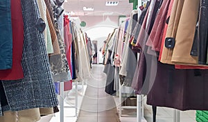 Clothes hanging on shelves in a designer clothing store. Clothes Shop. clothing aisle in a supermarket