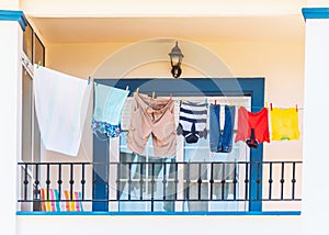 Clothes hanging on a washing line on a bright modern style blue and white balcony.