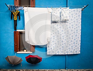 Clothes and linens drying outside of a house