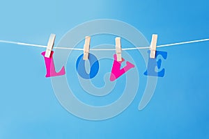 Clothes pegs and I LOVE YOU words on papers on rope on white background Valentines day concept.