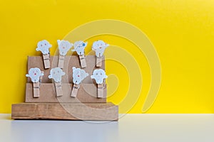 Clothes pegs with wooden teeth on yellow background.  Free space for text. Conceptual image