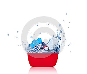 Clothes are in a plastic bowl with water, isolated on white