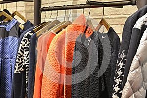 Clothes on racks in fashion shop photo