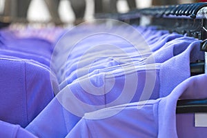 Clothes on clothes rail in clothing store. Interior of fashions outlet shop. photo