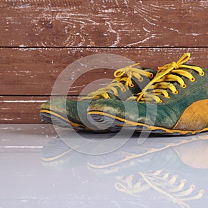 Clothes shoes and accessories - Old pair green  sneakers wooden background reflection