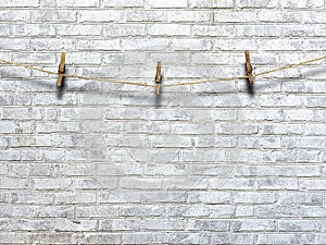 Clothesline with clothespins on a background of a brick wall