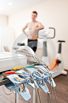 Clothespins of the ECG machine in the foreground. Athlete does a cardiac stress test and VO2 in a medical study