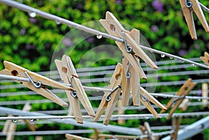 Clothespins on an outdoor laundry line as a light rain falls.