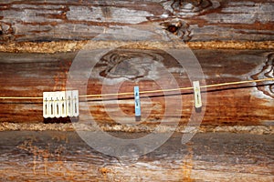 Clothespins on a rope against the background of a wooden log wall