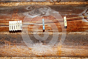 Clothespins on a rope against the background of a wooden log wall