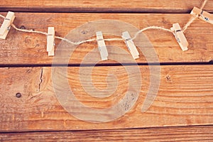 Clothespins on rope and empty wooden planks background. Copy space. Top view