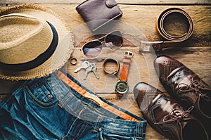 Clothing and accessories for men on wood floor.
