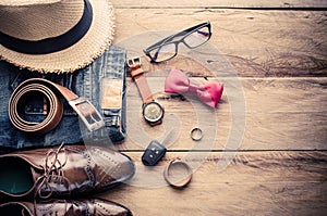 Clothing and accessories for travel on wood background.