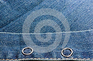 clothing items blue stonewashed faded jeans cotton fabric texture with seams, clasps, buttons and rivets, macro, close-up