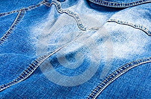 clothing items blue stonewashed faded jeans cotton fabric texture with seams, clasps, buttons and rivets, macro, close-up