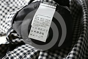 Clothing label with size and care instructions on checkered garment