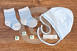 Clothing for newborn baby with word boy and pregnancy test with positive result