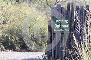 Clothing Optional Beyond this Point Sign on a Wood Fence photo