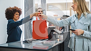 Clothing Store Checkout Cashier Counter: Woman and Male Retail Sales Managers Accept NFC Smartphone