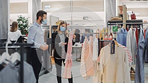 Clothing Store: Female Customer Shopping, Retail Sales Assistant Helps. Wearing Protective Face