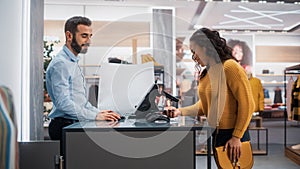 Clothing Store: Young Woman at Counter Buys Clothes from Friendly Retail Sales Assistant, Paying