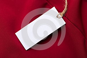Clothing tag, label blank mockup on a clothes.  fashion, people and shopping concept - close up price tag of clothing item