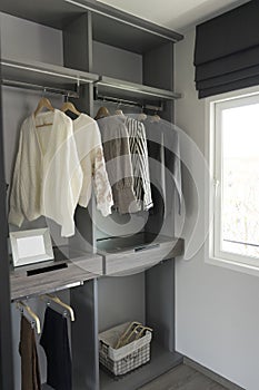 Cloths hanging in wooden wardrobe at home