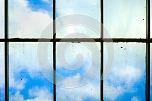 Cloud Behind A Very Dirty Dim Windows Full of Dust Dirt and Mildew That Need To Be Clean at The Top of High Rise Building photo