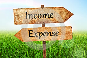 Income & expense Double Road signpost with blue sky background.