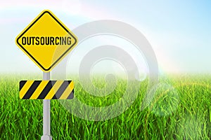 Outsourcing  sign on a yellow road sign.