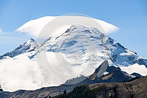 Cloud cap weather phenomenon hovers above the peak of Mount Baker