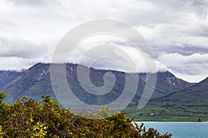 Cloud-capped peaks on the shores of Lake Wakatipu. New Zealand