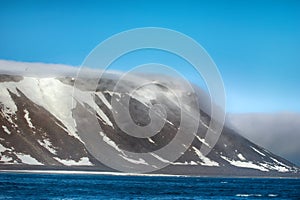 Cloud caught on the glacial sheet, nunatak in fog