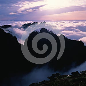 Cloud - covered Mountain Peaks at Dusk