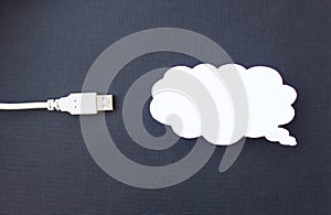 Cloud for data storage cut from paper on a black background and cable usb, close-up, data storage on the Internet photo
