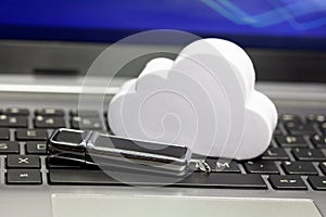 Cloud data storage technology, storing data in the cloud abstract. Cloud and a usb memory stick, pen drive laying on a laptop