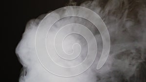 Cloud of exhaled vapor smoke moves across screen, isolated in dark background