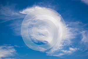 A cloud in the form of a feather or a wing against a blue sky